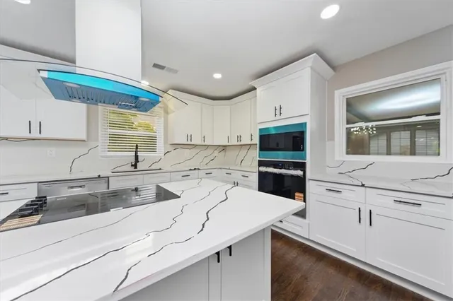 a kitchen with kitchen island a sink appliances and cabinets