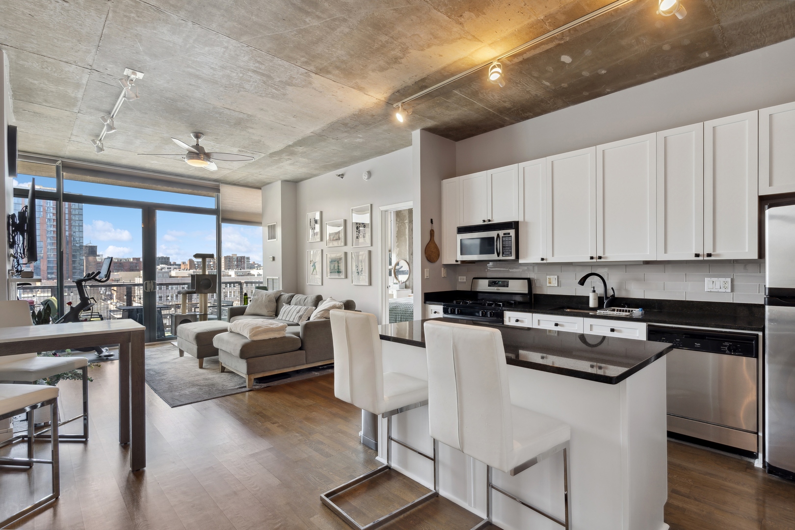 321 South Sangamon Street, Unit 603 Chicago, IL 60607 - Photo 5 of 12 a kitchen with stainless steel appliances granite countertop a stove top oven a sink dishwasher a dining table and chairs with wooden floor
