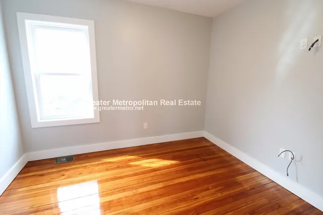 a view of a room with wooden floor and small window