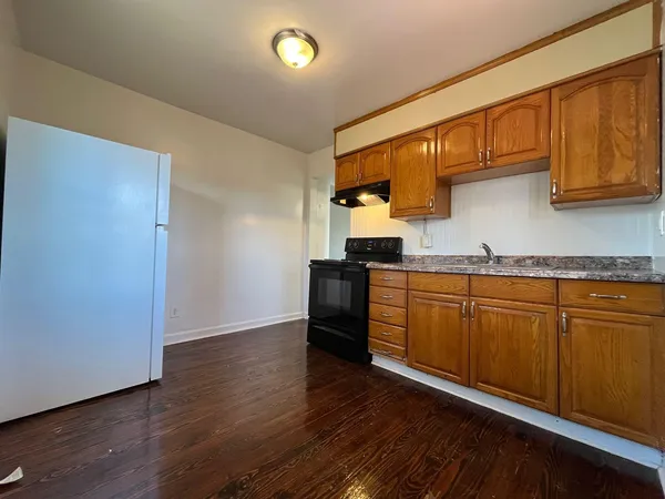 a kitchen with granite countertop wooden floors and stainless steel appliances