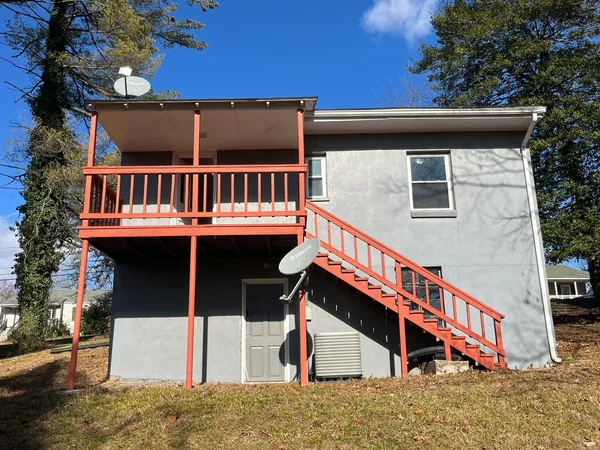 a view of house with roof deck and seating space