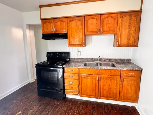 a kitchen with granite countertop wooden floors and wide window