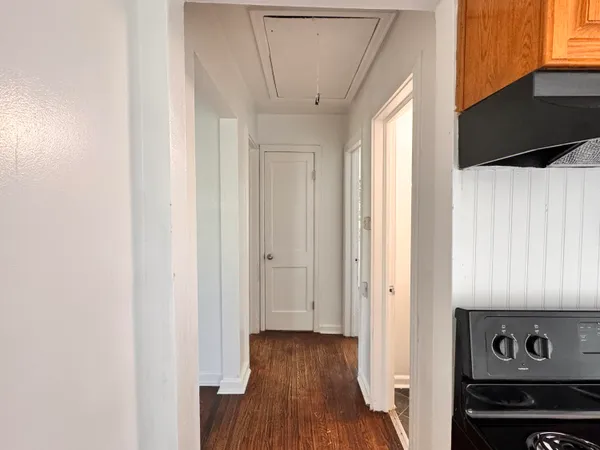 a view of a hallway with wooden floor and staircase