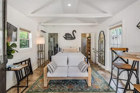 a bedroom with a bed and dresser with mirror