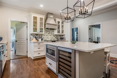 a kitchen with stainless steel appliances a sink cabinets and wooden floor