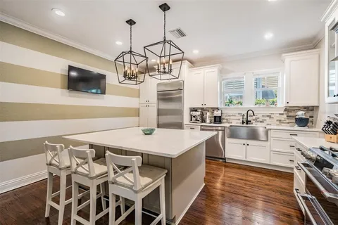 a kitchen with a stove a sink and chairs