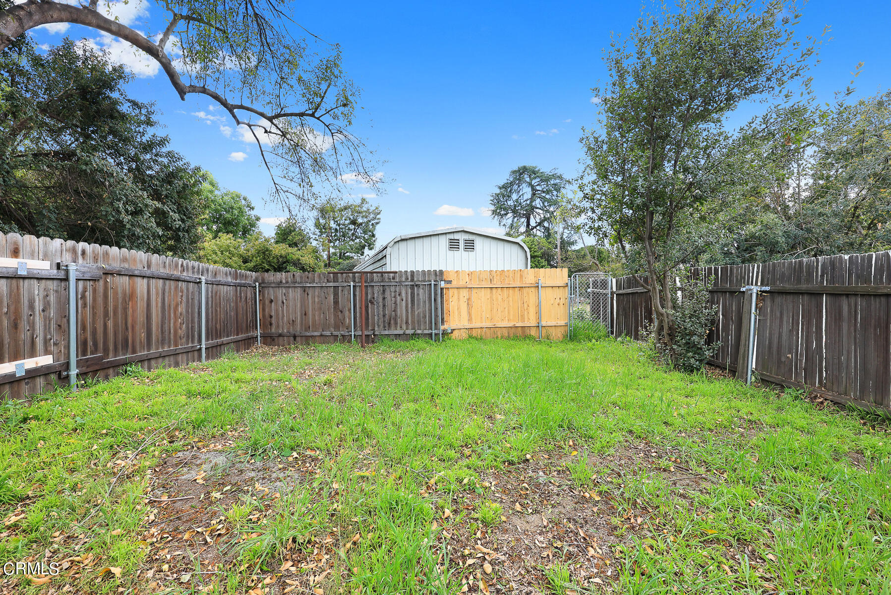 3570 Lombardy Road Pasadena, CA 91107 - Photo 36 of 45 a view of a backyard with large trees and wooden fence