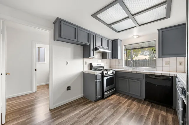 a kitchen with stainless steel appliances granite countertop a stove sink and refrigerator
