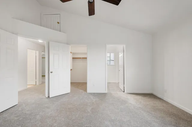 an empty room with ceiling fan and window