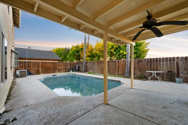 a view of backyard with swimming pool and outdoor seating