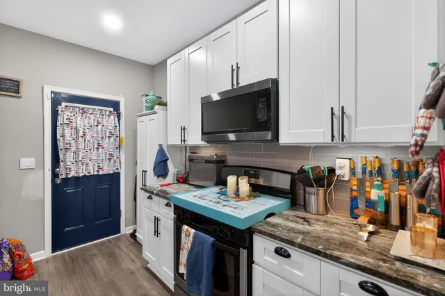 a view of kitchen with stainless steel appliances granite countertop a stove and a sink