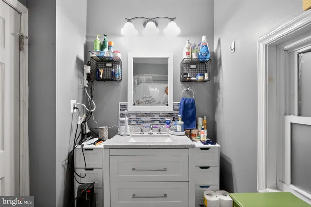 a bathroom with a sink vanity and mirror