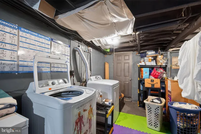 a utility room with dryer washer and a fireplace