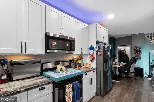 a kitchen with stainless steel appliances a stove refrigerator and microwave