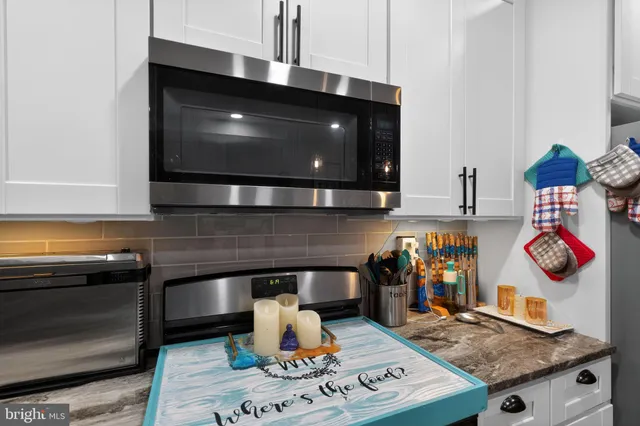 a kitchen with stainless steel appliances granite countertop a stove a microwave and cabinets