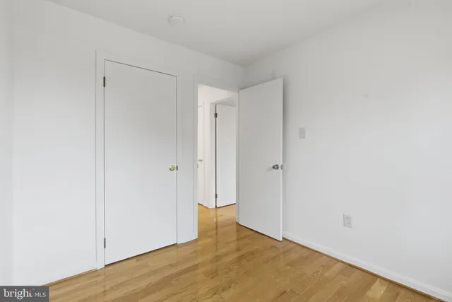 a view of an empty room with chandelier fan and fire place