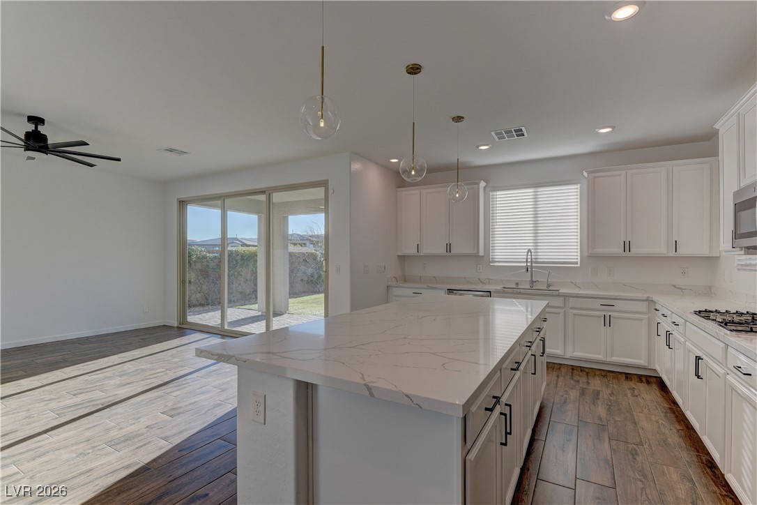 727 Foreign Reef Way Las Vegas, NV 89138 - Photo 9 of 25 Kitchen with a center island, decorative light fixtures, dark wood finished floors, white cabinets, and recessed lighting