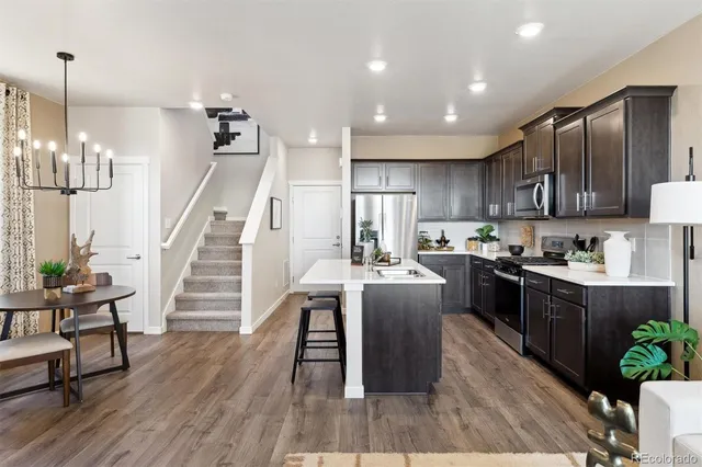 a kitchen with stainless steel appliances kitchen island granite countertop wooden floors and view living room