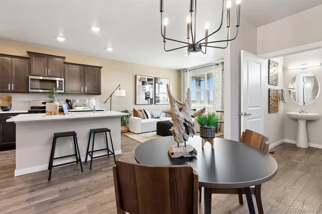 a living room with stainless steel appliances furniture a dining table and chairs