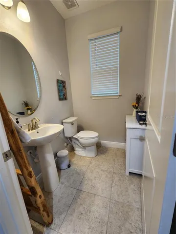 a bathroom with a sink toilet and a mirror