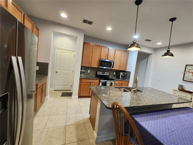 a kitchen with stainless steel appliances granite countertop a sink refrigerator and stove