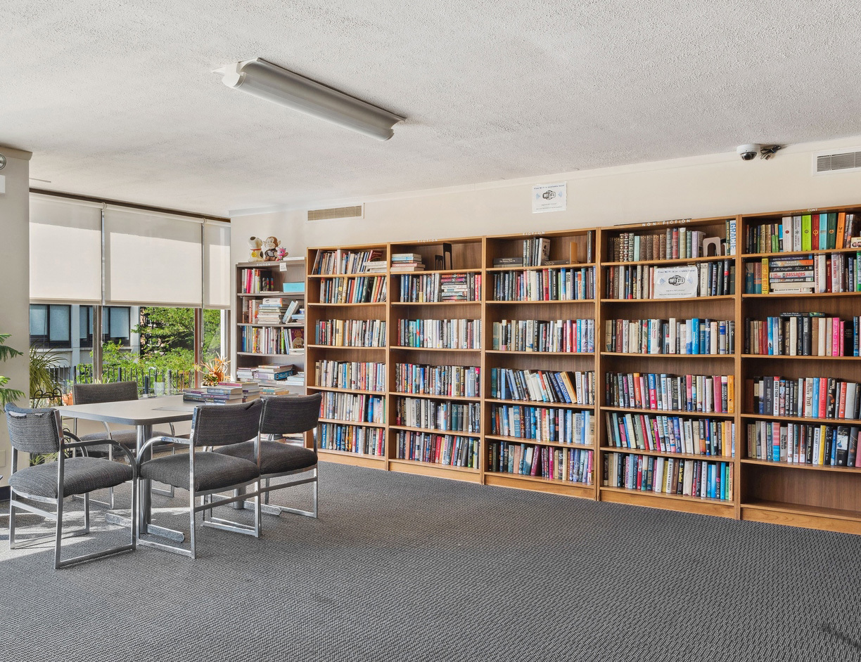 5455 North Sheridan Road, Unit 1708 Chicago, IL 60640 - Photo 12 of 20 a living room with furniture and a book shelf
