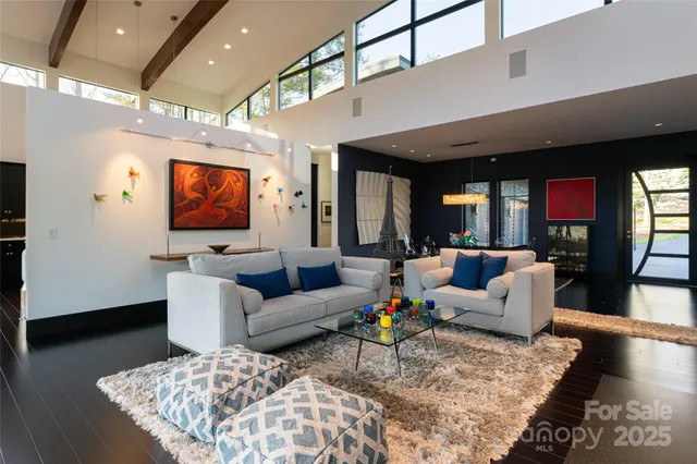 a living room with furniture wooden floor and a large window