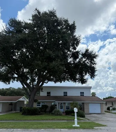 a view of house with outdoor space and tall trees