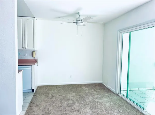 an empty room with a ceiling fan and a window