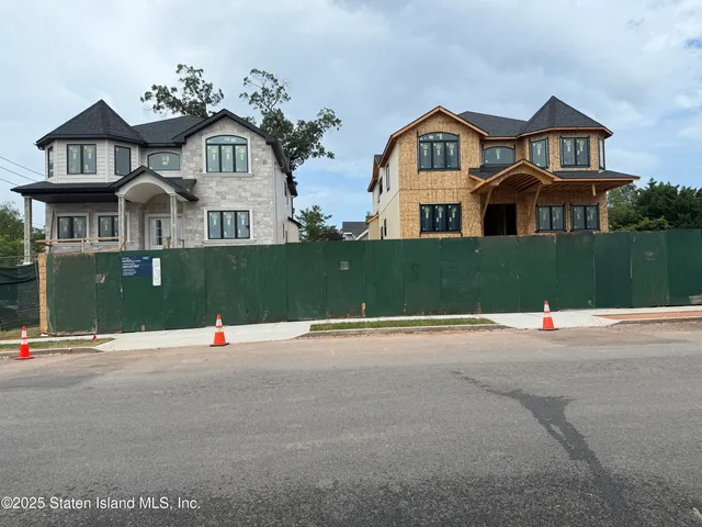 a front view of a house with a garden and parking area