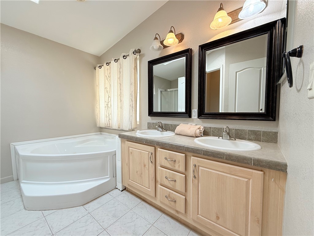 2350 Adobe Road Road, Unit 191 Bullhead City, AZ 86442 - Photo 34 of 52 a bathroom with a double vanity sink a mirror and a bathtub