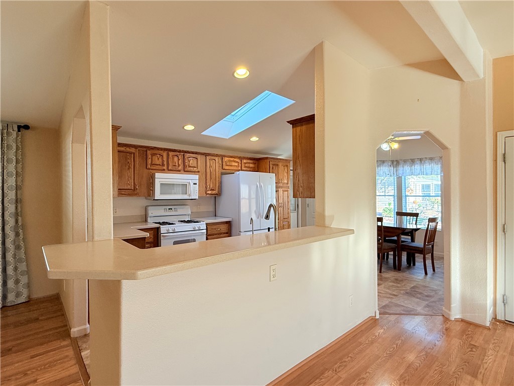 2350 Adobe Road Road, Unit 191 Bullhead City, AZ 86442 - Photo 6 of 52 a kitchen with stainless steel appliances kitchen island granite countertop a refrigerator a stove a sink a dining table and chairs with wooden floor