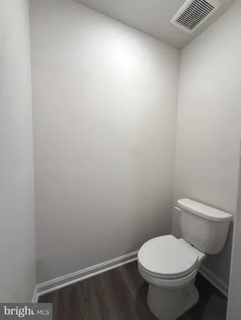 a white toilet sitting next to a white wall