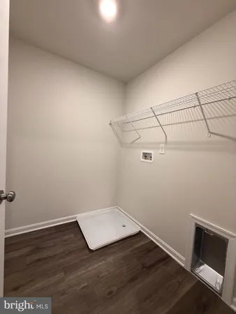 an empty room with wooden floor and fan