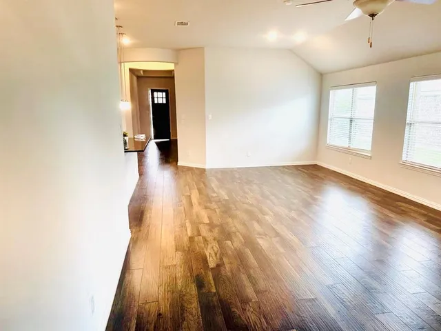 a view of a kitchen with a sink dishwasher and a refrigerator with wooden floor