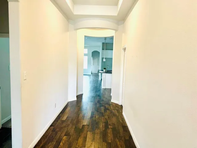 a view of a hallway with wooden floor