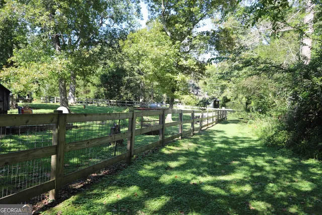 a view of backyard with table and chairs and wooden fence