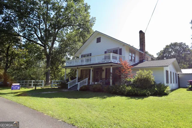 a front view of a house with garden and sitting area