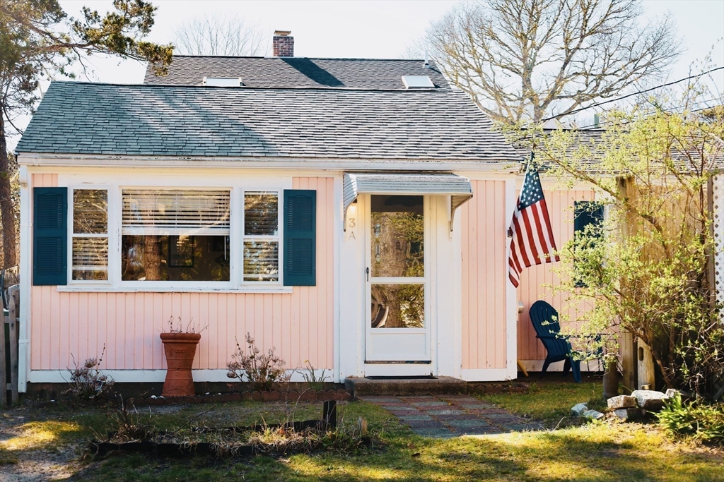 253 Shad Hole Road, Unit 3A Dennis, MA 02639 - Photo 1 of 25 a front view of a house with a yard garage and chair