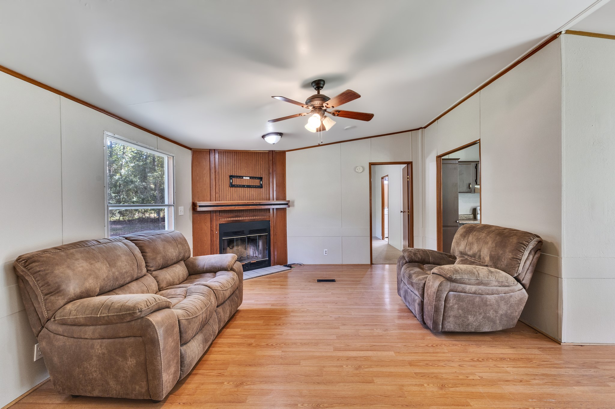 2009 Holder Rambo Drive Huffman, TX 77336 - Photo 14 of 31 Spacious living room featuring warm wood flooring, a cozy fireplace, and comfortable seating, perfect for relaxing or entertaining.