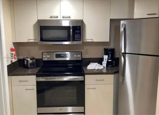 a kitchen with stainless steel appliances a stove microwave and refrigerator