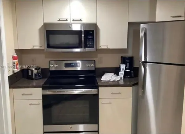 a kitchen with stainless steel appliances a stove microwave and refrigerator