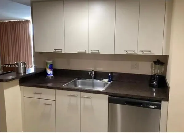 a kitchen with granite countertop a sink and cabinets