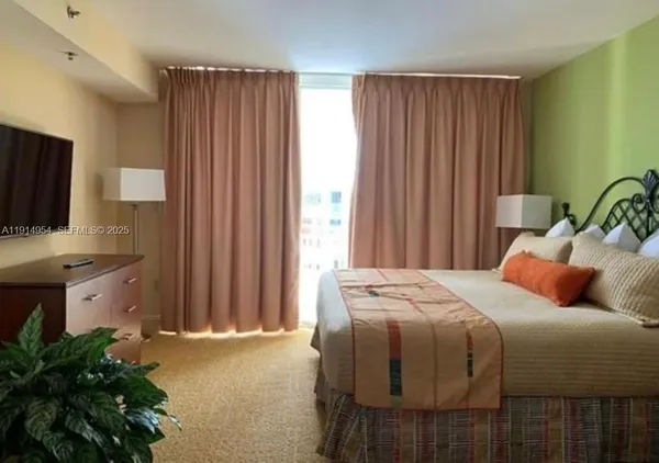 a bedroom with a bed and a potted plant