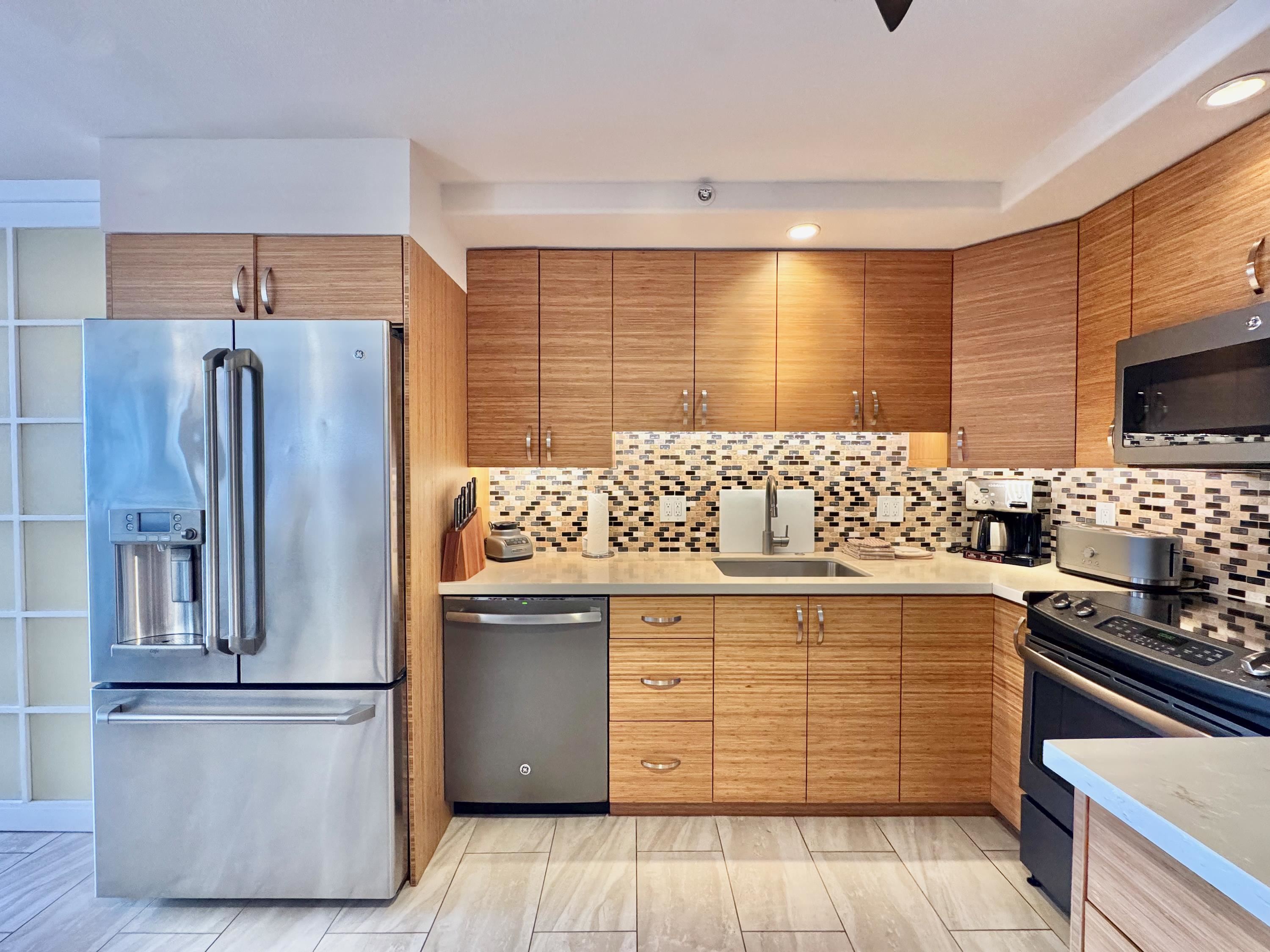 2960 South Kihei Road, Unit 209 Kihei, HI 96753 - Photo 5 of 43 a kitchen with stainless steel appliances granite countertop a refrigerator and a stove