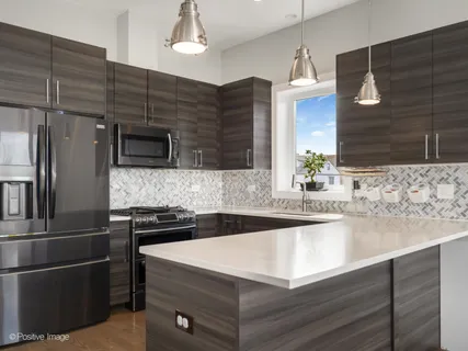 a kitchen with kitchen island a sink appliances and cabinets