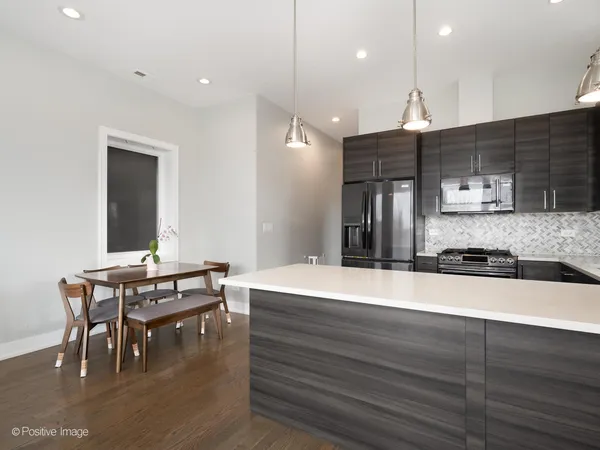 a large kitchen with a table and chairs