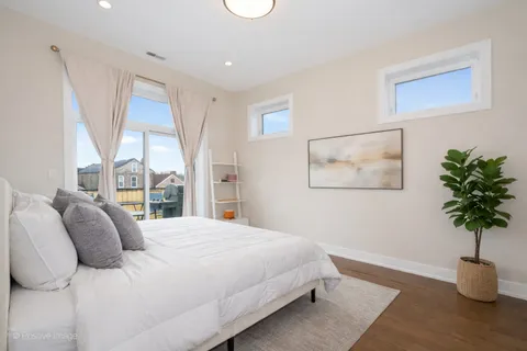 a bedroom with a large bed and a potted plant