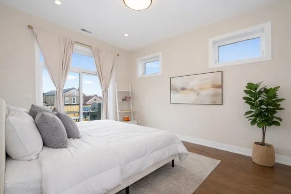 a bedroom with a large bed and a potted plant