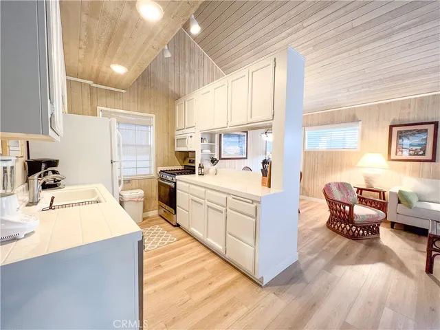 a large white kitchen with cabinets a sink and a stove